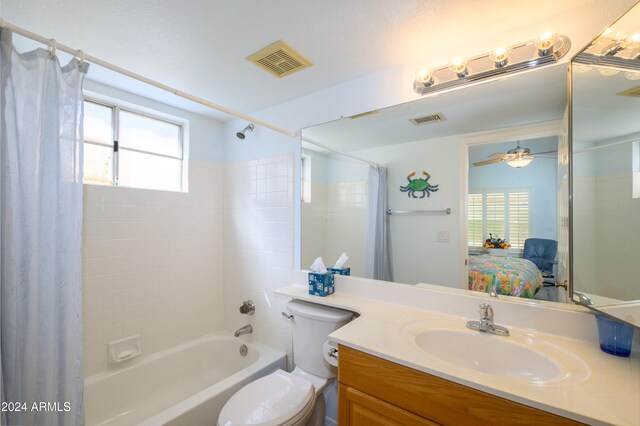 full bathroom with vanity, toilet, shower / tub combo with curtain, and ceiling fan