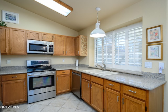 kitchen featuring lofted ceiling, hanging light fixtures, light tile patterned floors, appliances with stainless steel finishes, and sink