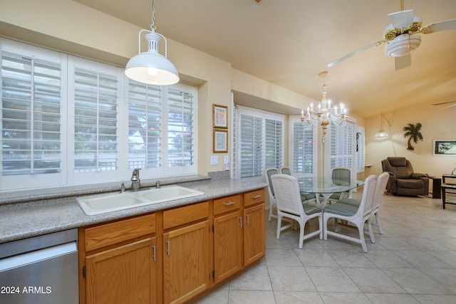 kitchen with sink, light tile patterned flooring, ceiling fan with notable chandelier, stainless steel dishwasher, and pendant lighting