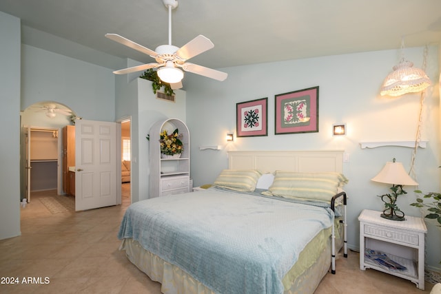 bedroom featuring lofted ceiling, light tile patterned flooring, and ceiling fan