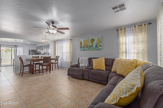 tiled living room with a textured ceiling and ceiling fan