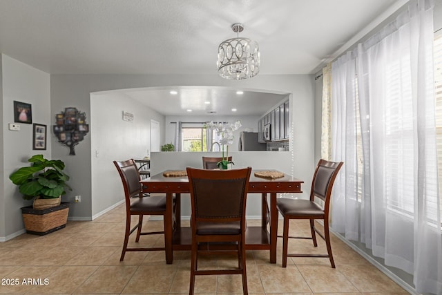 tiled dining space with a notable chandelier