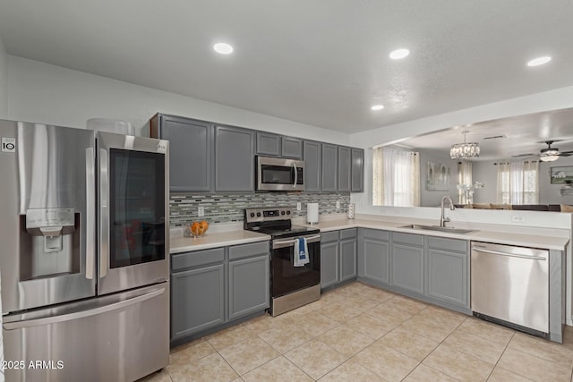 kitchen with sink, pendant lighting, stainless steel appliances, gray cabinets, and light tile patterned flooring