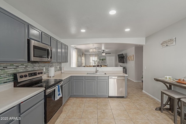 kitchen featuring decorative backsplash, gray cabinetry, sink, stainless steel appliances, and light tile patterned flooring