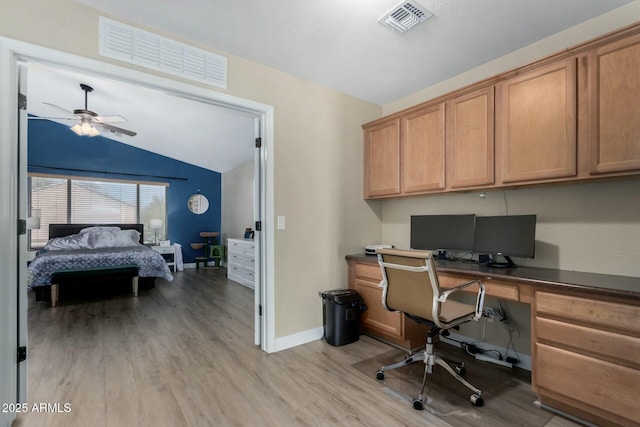 office area with ceiling fan, lofted ceiling, built in desk, and light hardwood / wood-style floors