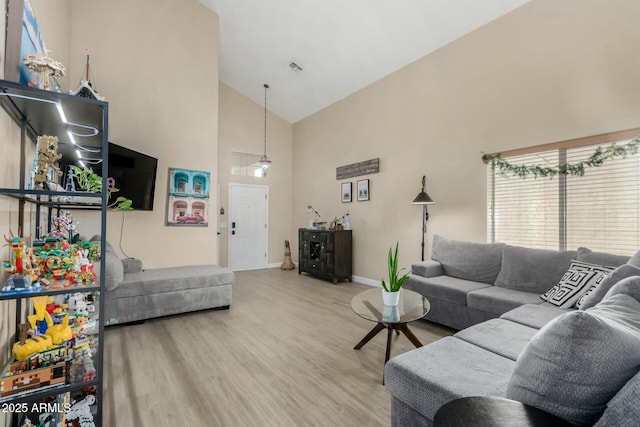 living room featuring wood-type flooring and high vaulted ceiling