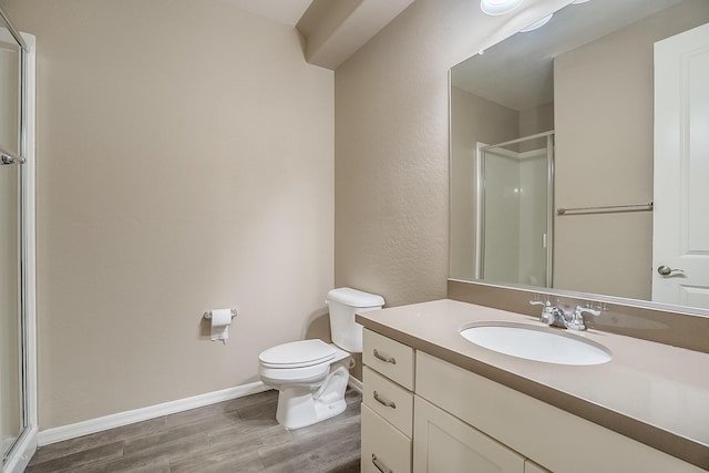 bathroom with wood-type flooring, vanity, toilet, and walk in shower