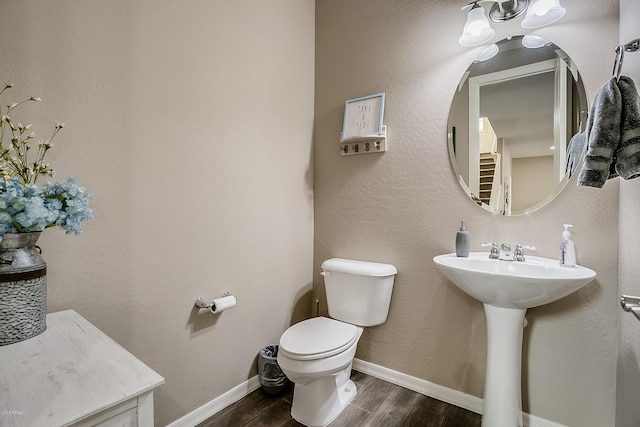 bathroom featuring wood-type flooring, toilet, and sink