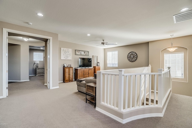 carpeted living room with ceiling fan