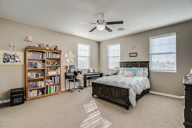 carpeted bedroom featuring multiple windows and ceiling fan