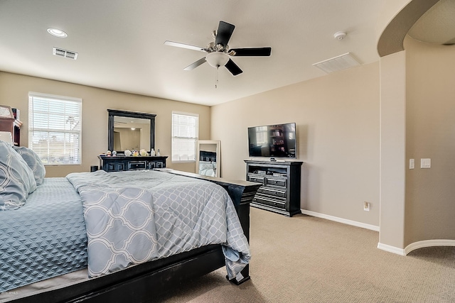 carpeted bedroom with ceiling fan and multiple windows