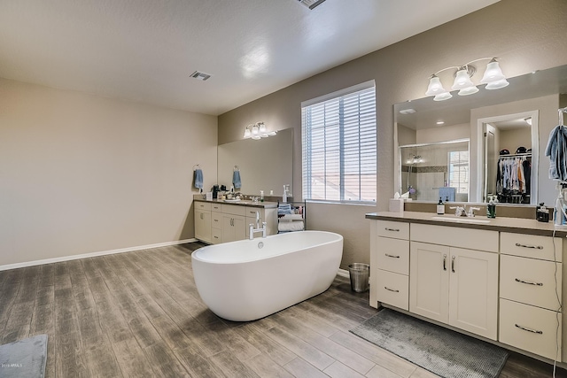 bathroom featuring wood-type flooring, vanity, and separate shower and tub