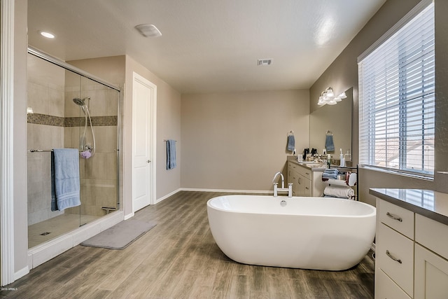 bathroom featuring hardwood / wood-style floors, vanity, and shower with separate bathtub