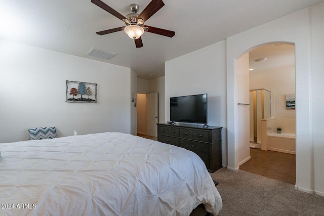 bedroom featuring light carpet, connected bathroom, and ceiling fan