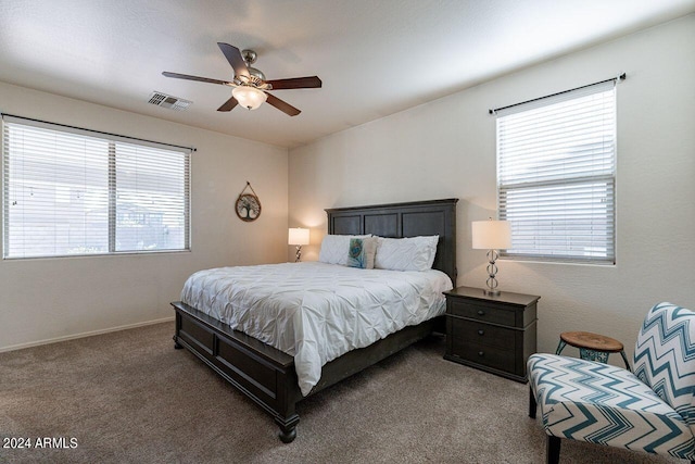 carpeted bedroom with multiple windows and ceiling fan