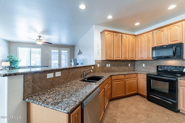 kitchen with black appliances, dark stone countertops, kitchen peninsula, sink, and ceiling fan