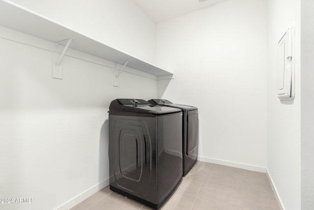 clothes washing area featuring light tile patterned floors and separate washer and dryer