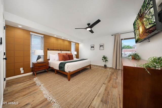 bedroom with light wood finished floors, baseboards, and recessed lighting