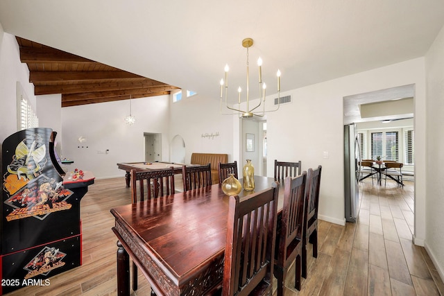 dining space with an inviting chandelier, wood finished floors, lofted ceiling with beams, visible vents, and baseboards