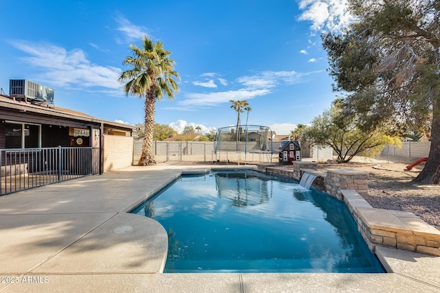 view of swimming pool with a trampoline, a patio, pool water feature, and central air condition unit