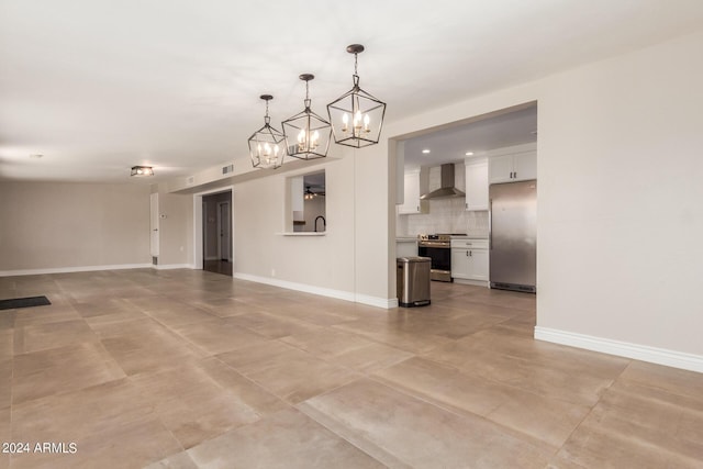 unfurnished living room with ceiling fan with notable chandelier