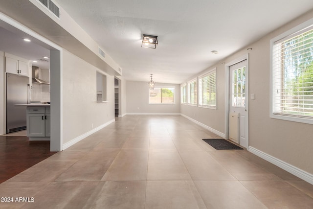 tiled entrance foyer with a notable chandelier and a wealth of natural light