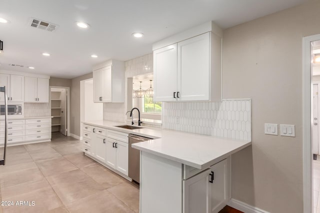 kitchen with kitchen peninsula, stainless steel appliances, white cabinetry, and sink