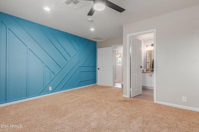 unfurnished bedroom featuring ceiling fan, light colored carpet, and connected bathroom