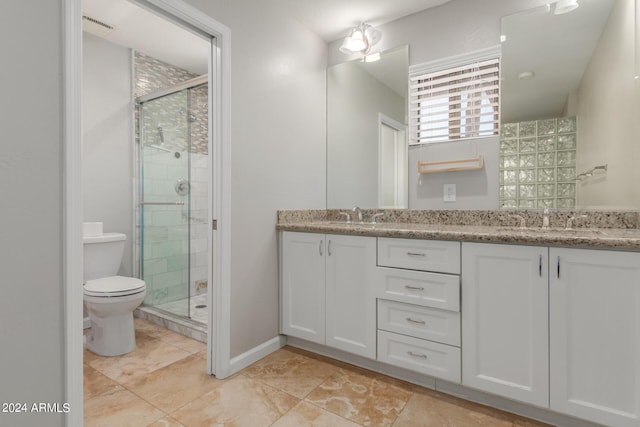 bathroom with vanity, toilet, and a shower with shower door