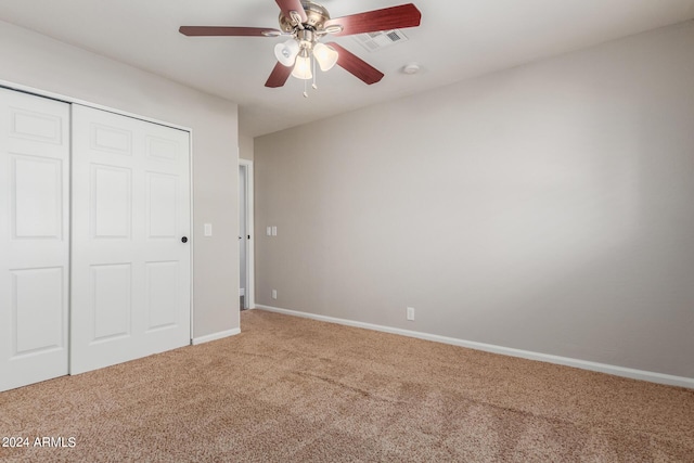 unfurnished bedroom with ceiling fan, a closet, and carpet floors