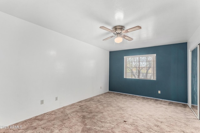 carpeted empty room with a ceiling fan