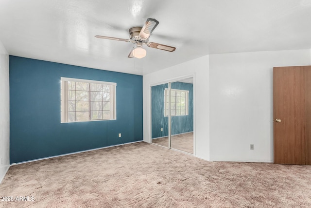 unfurnished bedroom with ceiling fan, a closet, and carpet