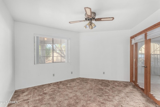 empty room with carpet, a ceiling fan, and a wealth of natural light