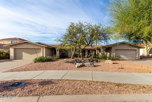 ranch-style house featuring a garage, driveway, and stucco siding