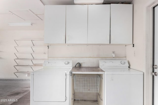 washroom featuring cabinet space and washing machine and clothes dryer