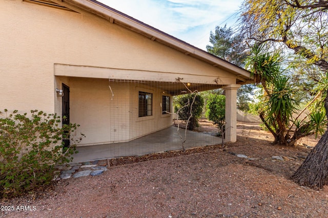 back of property with a patio area and stucco siding