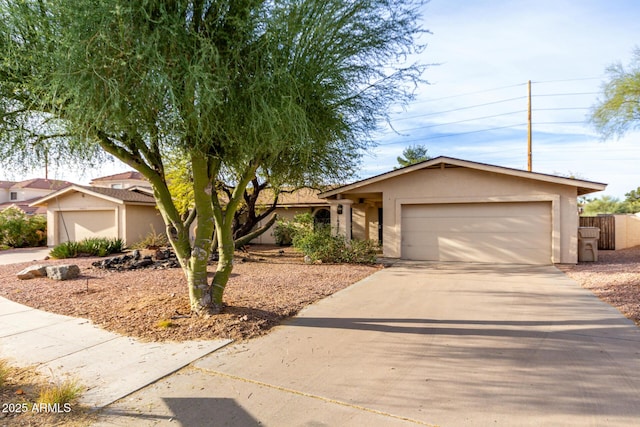 view of front of house with a garage, concrete driveway, and stucco siding