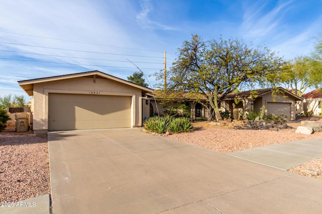 ranch-style house featuring driveway, an attached garage, and stucco siding