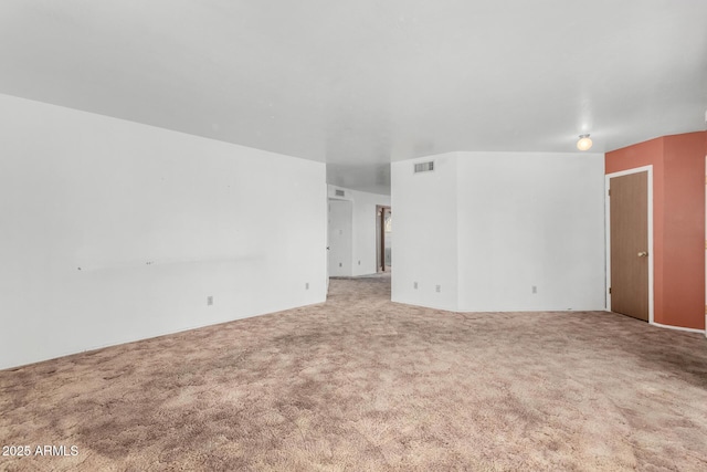 carpeted empty room featuring visible vents