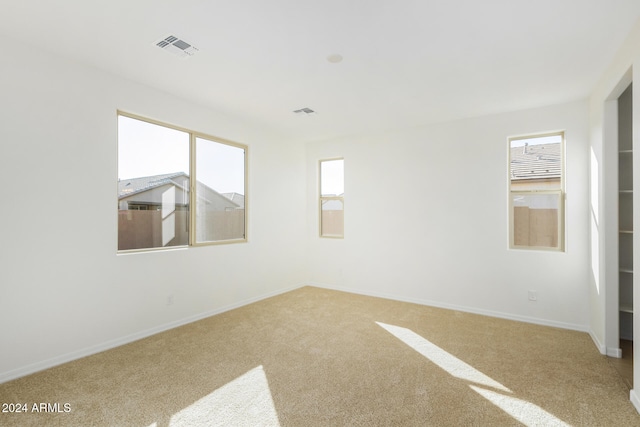 carpeted spare room featuring a healthy amount of sunlight