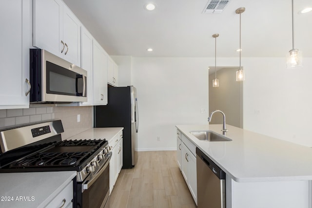 kitchen with white cabinets, decorative light fixtures, stainless steel appliances, and sink