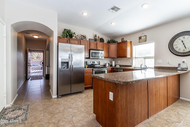 kitchen with lofted ceiling, sink, light tile patterned floors, kitchen peninsula, and stainless steel appliances