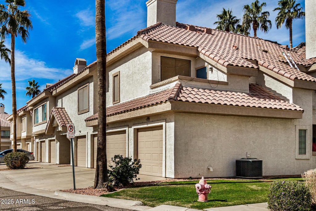 view of side of home with cooling unit and a garage