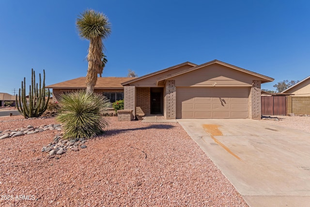 6534 S Marilyn Ann Dr, Tempe, AZ 85283 - view of front of house with brick siding, an attached garage, concrete driveway, and fence