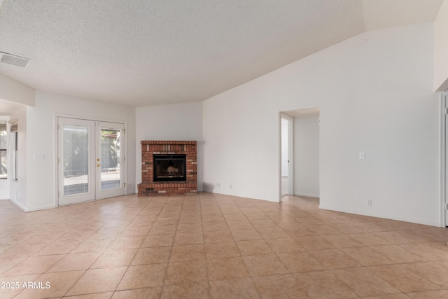 6534 S Marilyn Ann Dr, Tempe, AZ 85283 - unfurnished living room with visible vents, a textured ceiling, french doors, light tile patterned flooring, and vaulted ceiling