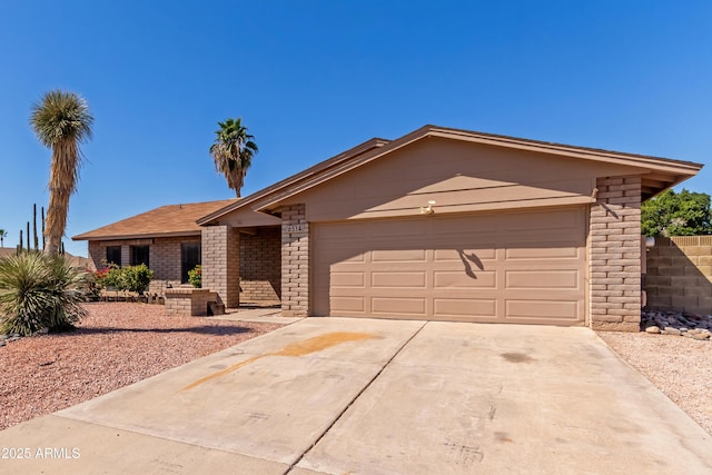 6534 S Marilyn Ann Dr, Tempe, AZ 85283 - view of front of home featuring concrete driveway, brick siding, and a garage