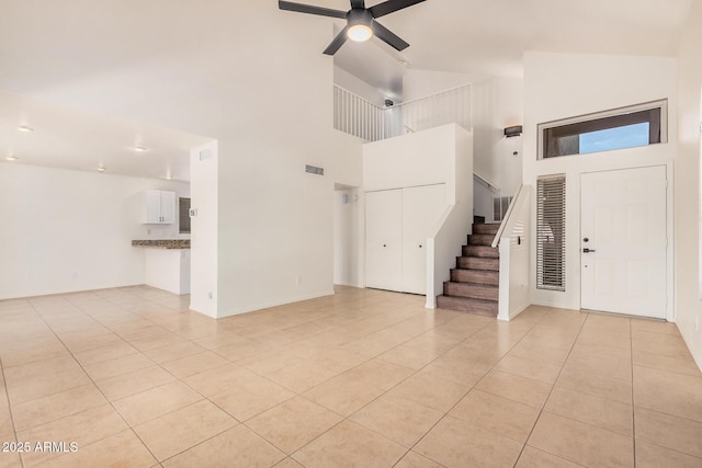 15440 S 38th St, Phoenix, AZ 85044 - unfurnished living room with high vaulted ceiling, light tile patterned floors, stairway, ceiling fan, and baseboards