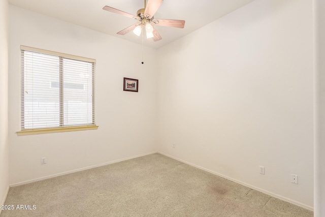 unfurnished room with light colored carpet, baseboards, and ceiling fan