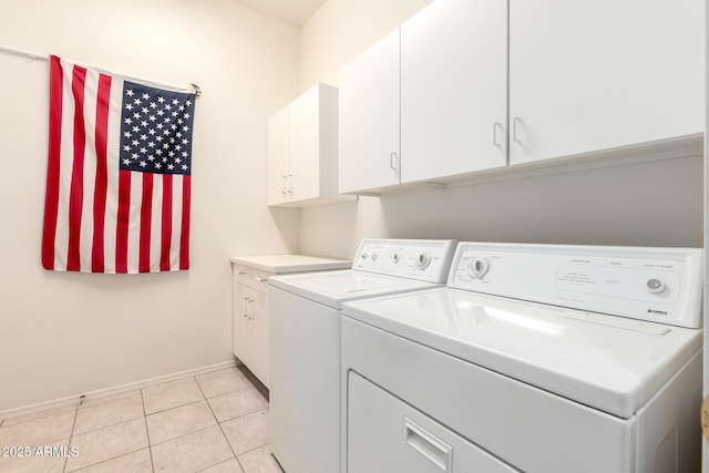 laundry room featuring baseboards, cabinet space, light tile patterned flooring, and washer and clothes dryer