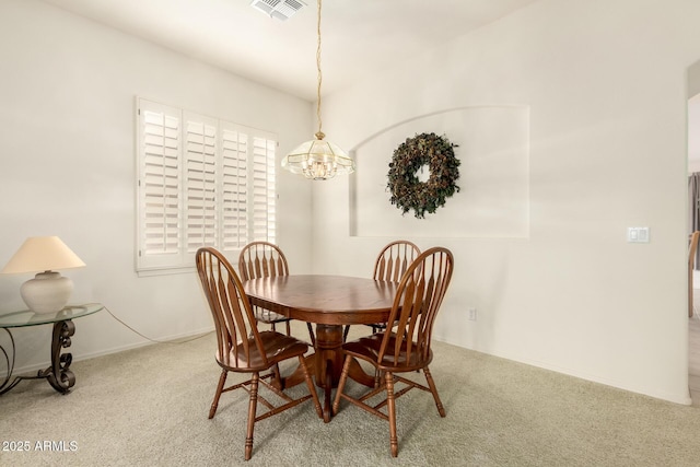 carpeted dining area with visible vents, baseboards, and a chandelier